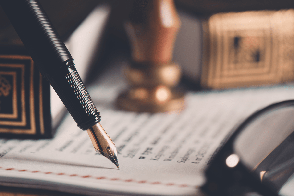 Fountain pen on a legal document with law books
